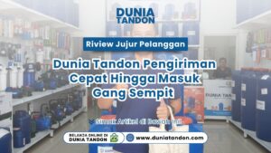 Pria berbaju biru berdiri di dalam toko tandon sambil memegang tas belanja kain putih sebagai bentuk testimoni puas pelanggan
