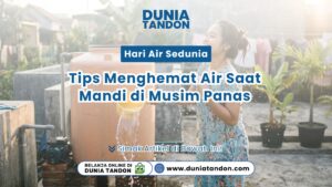 Seorang wanita tersenyum segar sedang mandi menyiram air menggunakan gayung di samping tangki air oren Toko Dunia Tandon